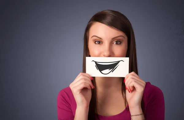 Ευτυχισμένος χαριτωμένο κορίτσι εκμετάλλευση χαρτί με αστεία smiley σχέδιο — Φωτογραφία Αρχείου