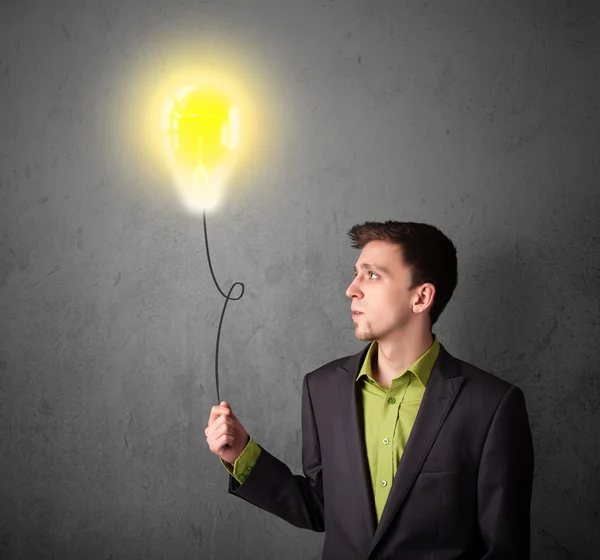 Businessman holding a lightbulb balloon — Stock Photo, Image