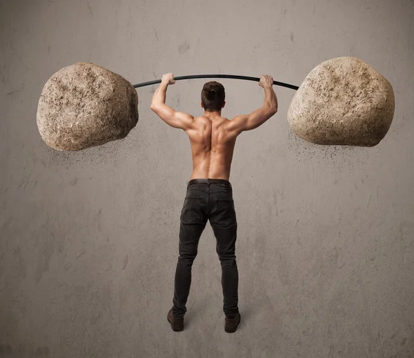 Muscular man lifting large rock stone weights — Stock Photo, Image