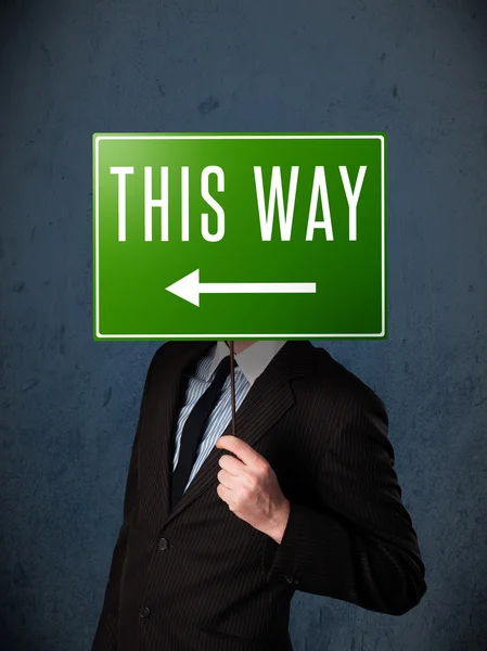 Businessman holding a direction sign — Stock Photo, Image