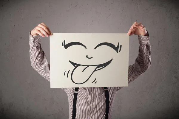 Empresário segurando um papel com cara sorridente engraçado na frente de h — Fotografia de Stock