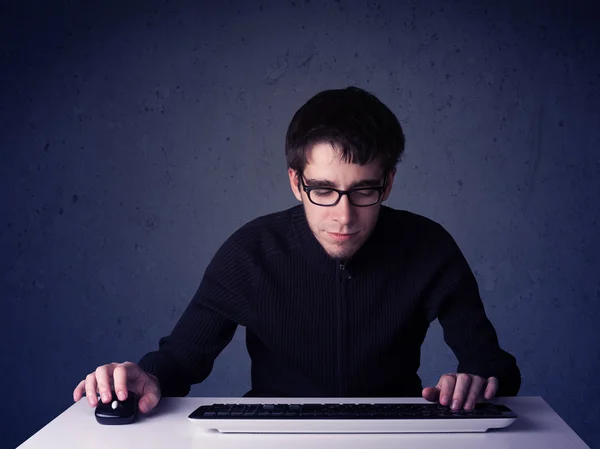 Хакер работает с клавиатурой на синем фоне — стоковое фото