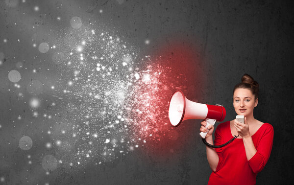 Женщина кричит в мегафон и исследует светящиеся частицы энергии
