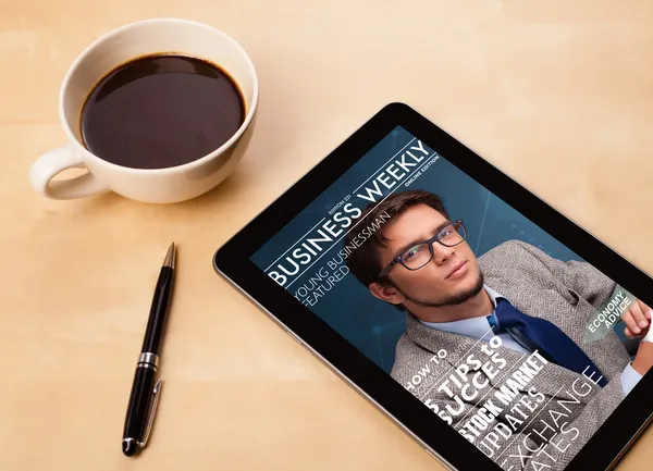 Tablet PC que muestra la revista en pantalla con una taza de café en una d — Foto de Stock