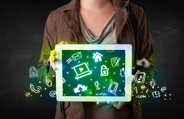 Person holding tablet with green media icons and symbols — Stock Photo, Image