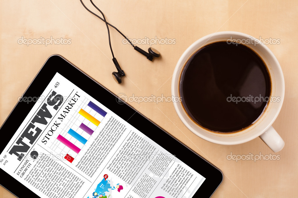 Tablet pc shows news on screen with a cup of coffee on a desk