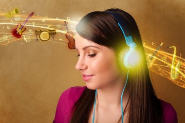 Kulaklıklı genç bir kadın müzik dinliyor.