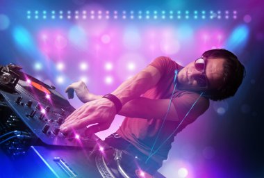 Disc jockey mixing music on turntables on stage with lights and clipart