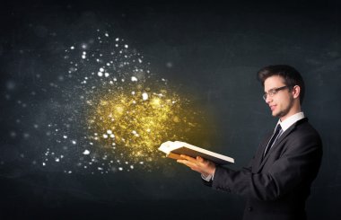 Genç adam sihirli bir kitap okuyor.