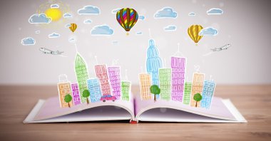 Açık kitap üzerine şehir manzarası çizimi