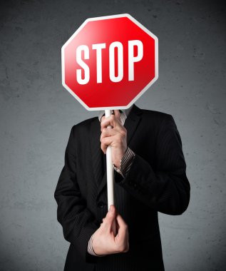 İşadamı elinde dur levhası tutuyor.
