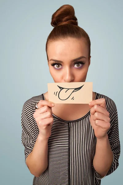 Pretty young girl holding white card with smile drawing — Stock Photo, Image