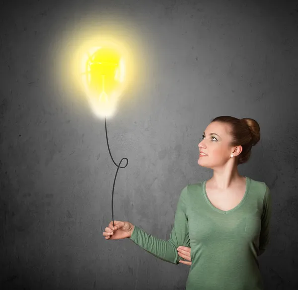 Woman holding a lightbulb balloon — Stock Photo, Image