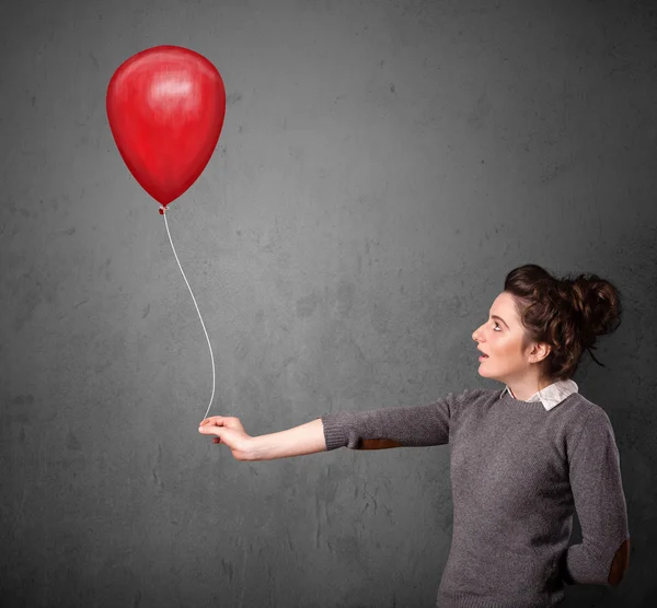 Kobieta trzymająca czerwony balon — Zdjęcie stockowe