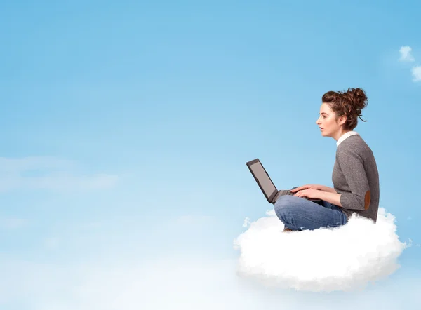 Young woman with laptop sitting on cloud with copy space — Stock Photo, Image