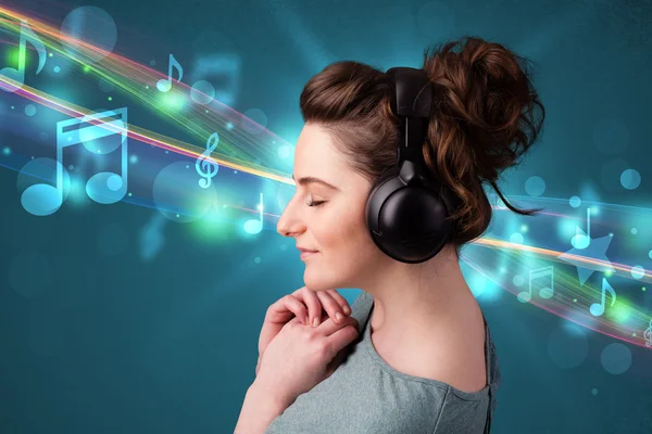 Mladá žena poslouchá hudbu se sluchátky — Stock fotografie