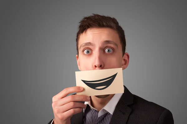 Happy businessman holding funny white card on his mouth — Stock Photo, Image