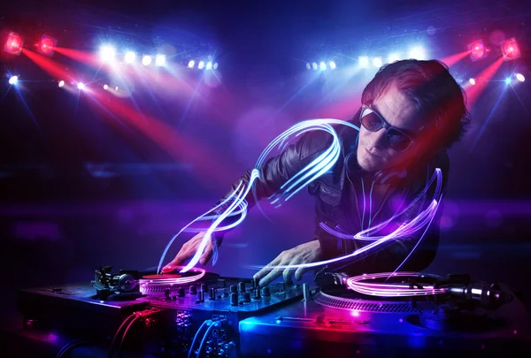 Disc jockey playing music with light beam effects on stage — Stock Photo, Image