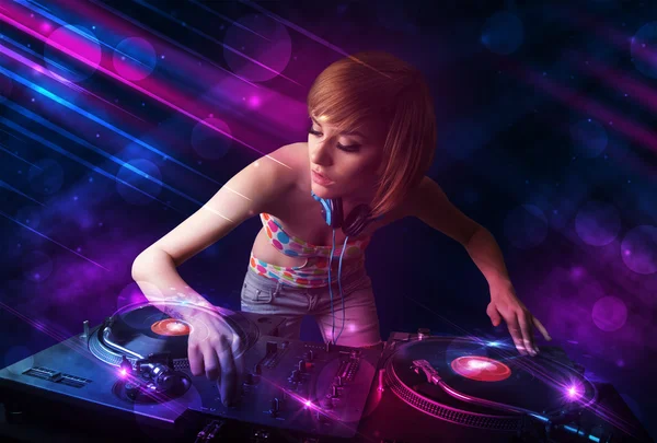 Giovane DJ che suona su giradischi con effetti di luce a colori — Foto Stock