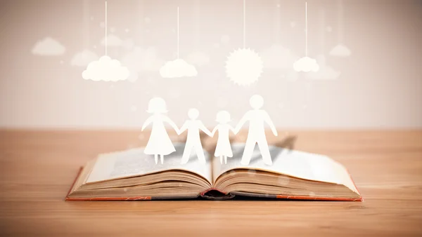 Cardboard figures of the family on opened book — Stock Photo, Image