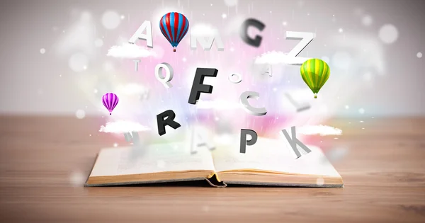 Open book with flying 3d letters on concrete background — Stock Photo, Image