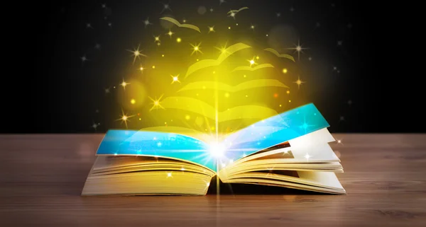 Open boek met gouden gloed vliegende papieren pagina 's — Stockfoto