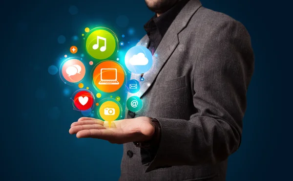 Young businessman presenting colorful technology icons and symbo — Stock Photo, Image