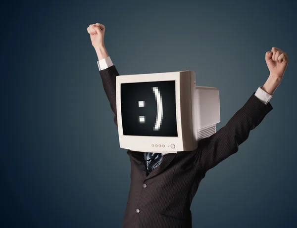 Funny young businessman with a monitor on his head and smiley on — Stock Photo, Image