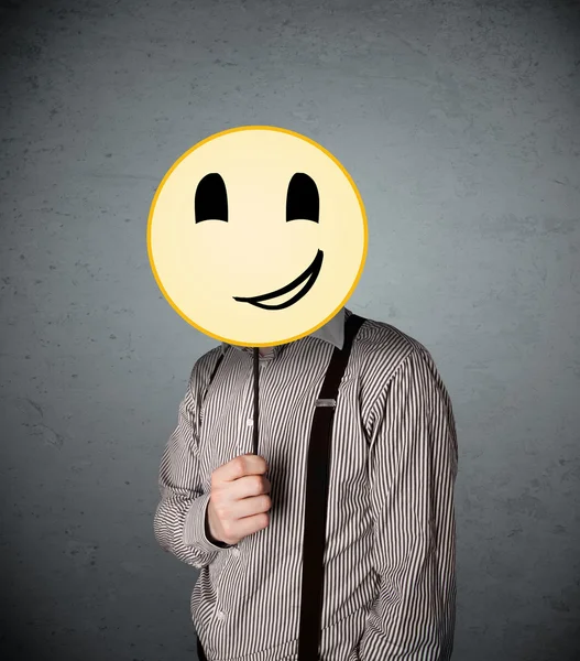 Businessman holding a smiley face emoticon — Stock Photo, Image