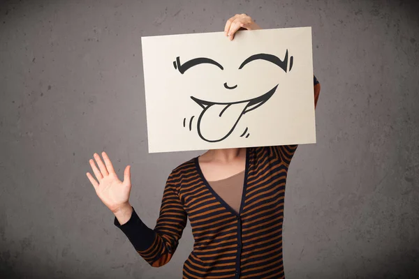 Vrouw met een papier met leuke smileygezicht op het voor hij — Stockfoto