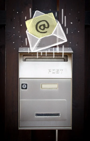 Конверт с почтовым знаком, опускающимся в почтовый ящик — стоковое фото