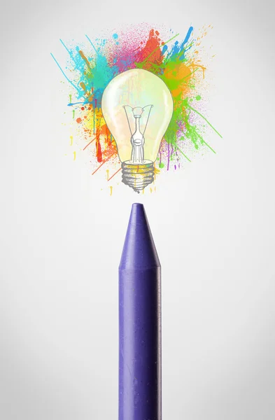 Crayon närbild med färgade färgstänk och glödlampa — Stockfoto