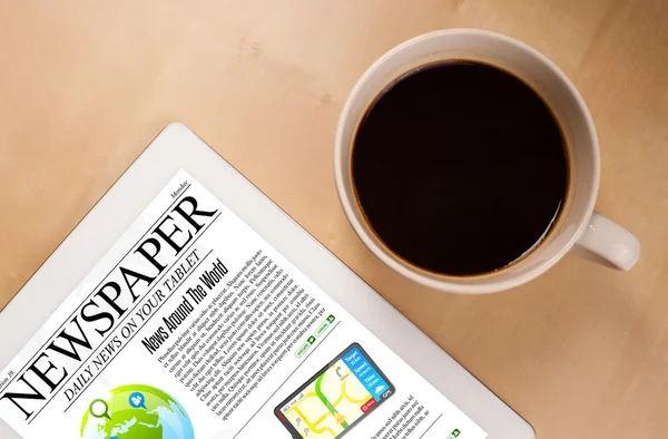 Tablet-PC zeigt Nachrichten auf dem Bildschirm mit einer Tasse Kaffee auf dem Schreibtisch — Stockfoto