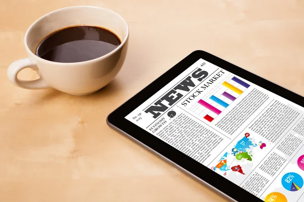 Tablet bilgisayarı haberleri ekranda bir fincan kahveyle sunar.