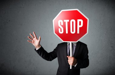 İşadamı elinde dur levhası tutuyor.