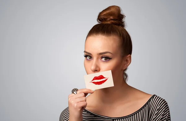 Feliz mulher bonita segurando cartão com marca batom beijo — Fotografia de Stock