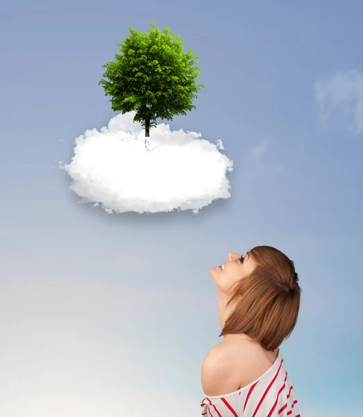 Niña apuntando a un árbol verde en la parte superior de una nube blanca — Foto de Stock