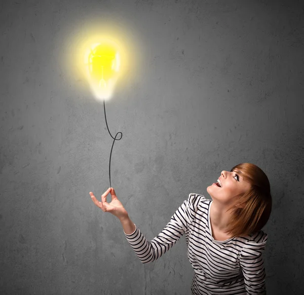 Woman holding a lightbulb balloon — Stock Photo, Image