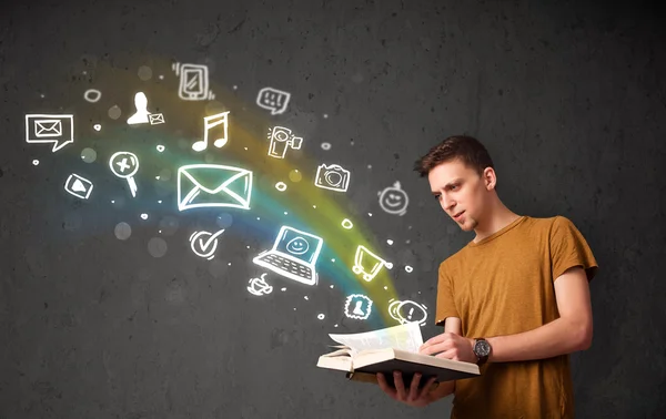 Young guy reading a book with multimedia icons coming out of the — Stock Photo, Image