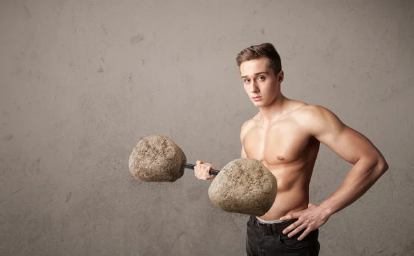 Muscular man lifting large rock stone weights — Stock Photo, Image