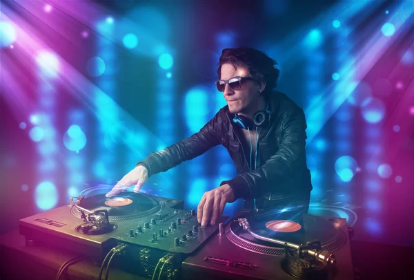 DJ miksowania muzyki w klubie z niebieski i fioletowy światła — Zdjęcie stockowe