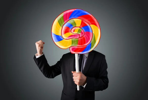 Businessman holding a lollipop — Stock Photo, Image