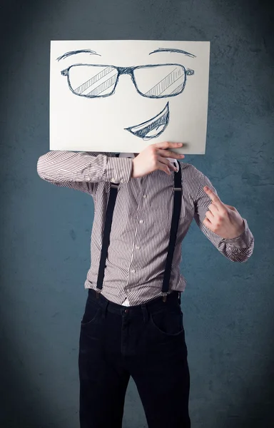 Empresario sosteniendo un papel con la cara sonriente delante de su hea — Foto de Stock