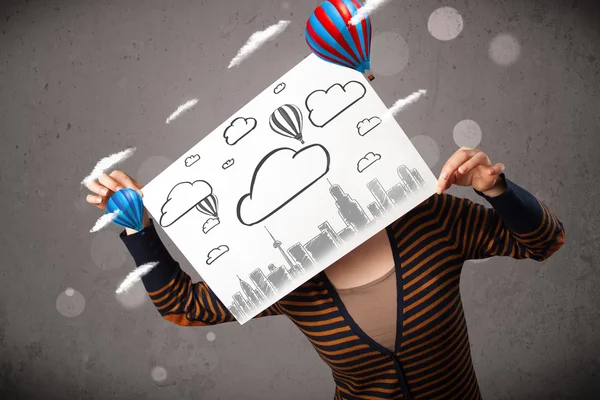 Woman holding a cardboard with cityscape in front of her head — Stock Photo, Image