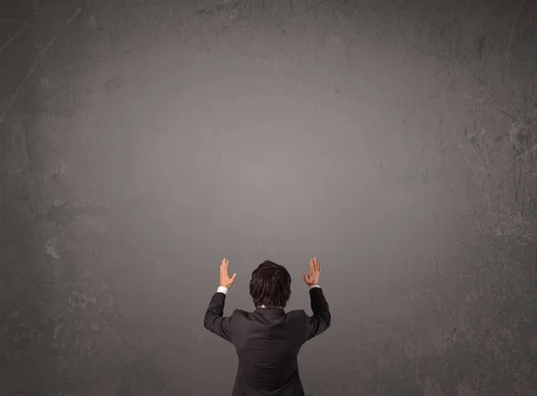 Businessman standing in front of an empty wall — Stock Photo, Image