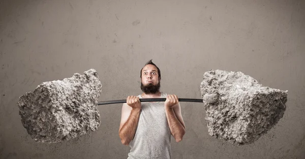 Skinny guy lifting large rock stone weights — Stock Photo, Image