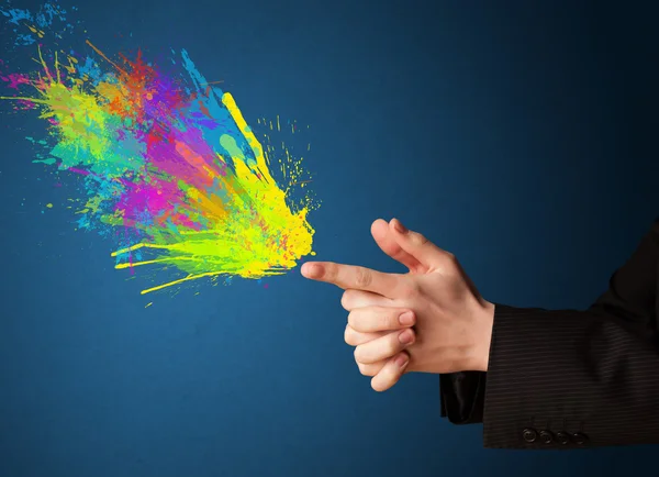 Colorful splashes are coming out of gun shaped hands — Stock Photo, Image