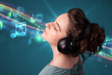 Kulaklıkla müzik dinleyen genç bir kadın.