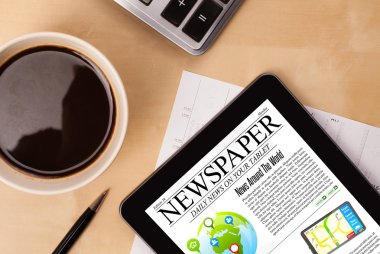 Tablet bilgisayarı haberleri ekranda bir fincan kahveyle sunar.