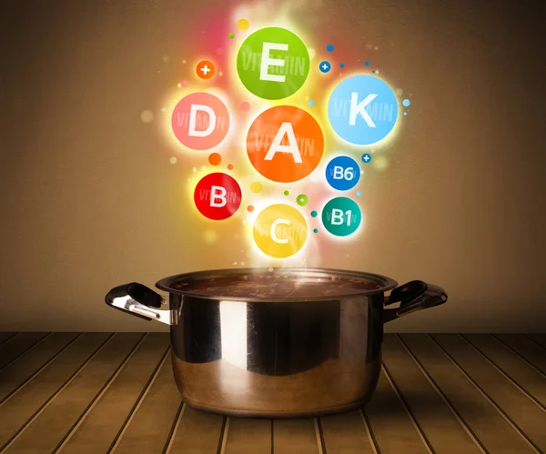 Colorful vitamins coming out from cooking pot — Stock Photo, Image